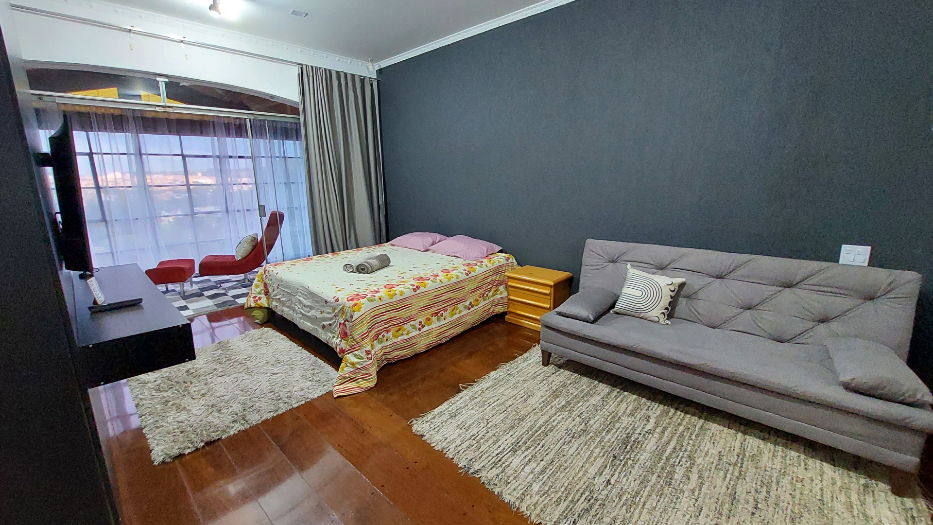 Quarto amplo com cama de casal e sofá